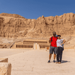 Couple posing in front of Hatshepsut Temple in the Valley of the Kings, Egypt, exploring the ancient wonders with Discovery Tours Egypt.